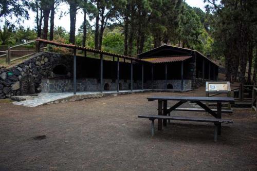 a picnic table in front of a stone building at Alojamiento dondequiera I in Breña Baja