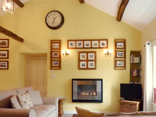 a living room with a fireplace and a clock on the wall at High White Stones in Ambleside