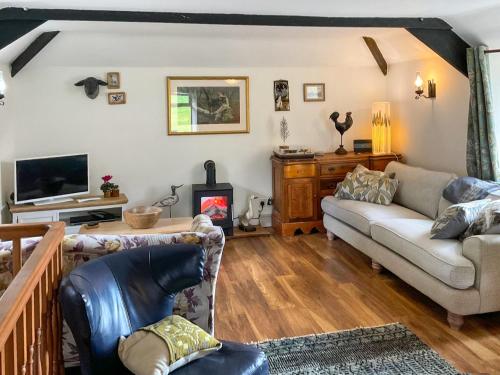 ein Wohnzimmer mit Sofa und Fernseher in der Unterkunft Kielder Cottage Spa - E3533 in Kielder