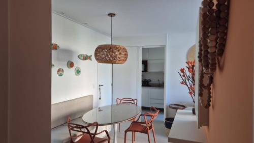 ein Esszimmer mit Glastisch und Stühlen in der Unterkunft Villa sol e mar, seu refúgio em Muro Alto in Ipojuca