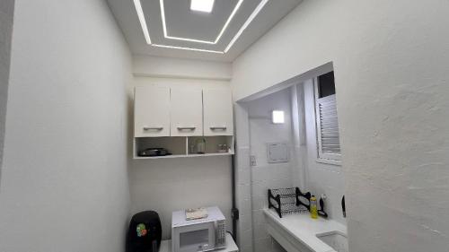 baño pequeño con fregadero y microondas en Excelente perto do Aeroporto e Metro e 3 km das Praias, en Río de Janeiro