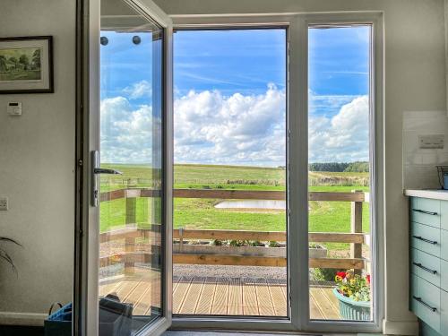 DishforthにあるRaygill Shepherds Hutの野原の景色を望むガラスの引き戸
