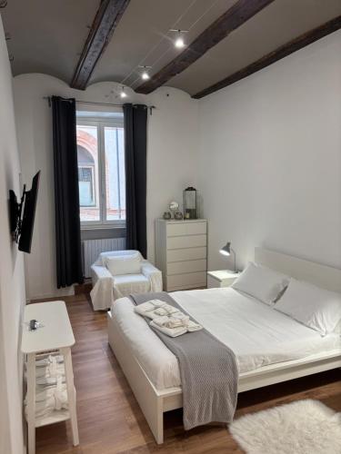 een slaapkamer met een groot wit bed en een raam bij Arco Antico in Alba