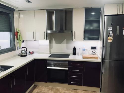 a kitchen with black and white cabinets and a refrigerator at Cuco in Requena