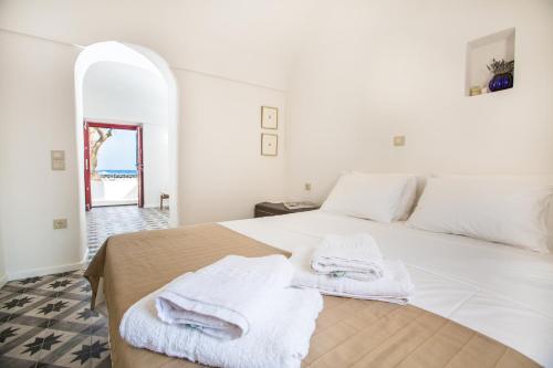 a bedroom with a white bed with towels on it at Sunhaus in Perissa