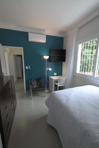 a bedroom with a bed and a desk and a window at 4 quartos Conforto e silêncio no coração de BH in Belo Horizonte