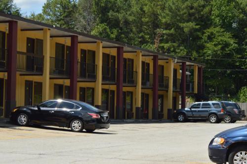 two cars parked in a parking lot in front of a building at Sun Down Lodge in Locust Grove