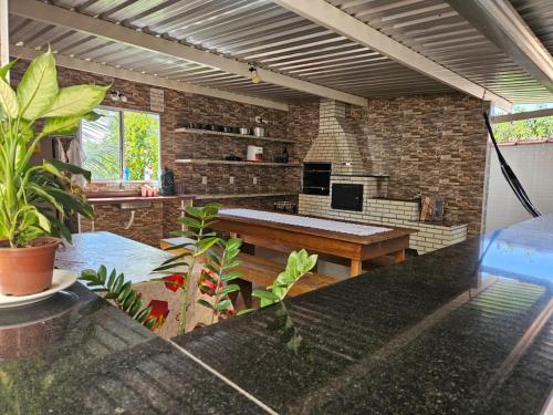 ein Wohnzimmer mit einem Tisch und einer Ziegelwand in der Unterkunft Casa de temporada - PISCINA, FOGÃO A LENHA E CHURRASQUEIRA in Lindóia