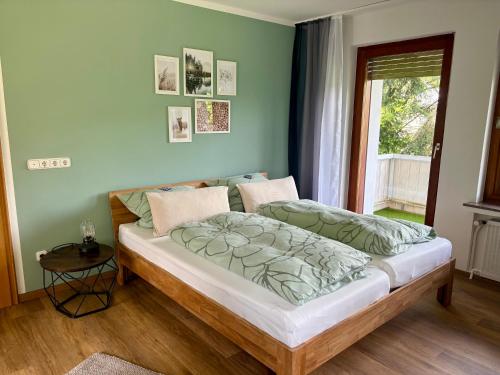 a bedroom with a large bed with green walls at FeWo Linneweber in Willingen
