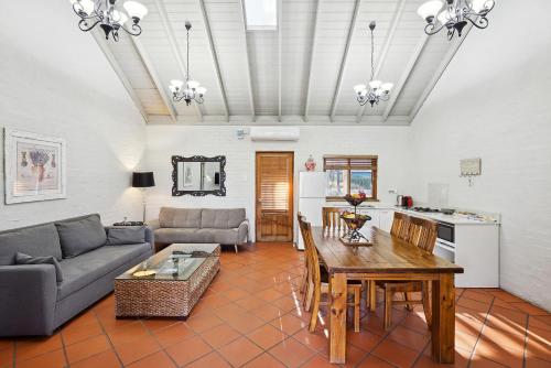 a living room with a couch and a table at Thistle Hill Guesthouse - walk to many wineries and restaurants in Pokolbin