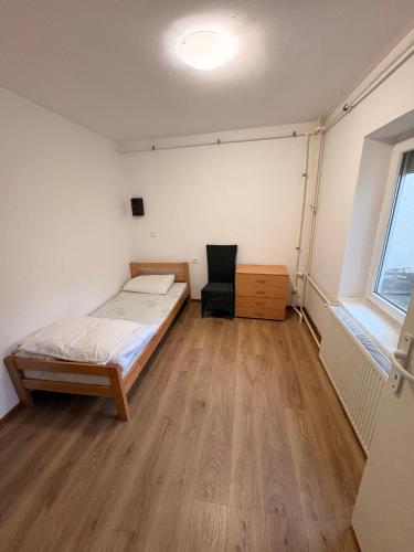 Un dormitorio con una cama y una silla dentro. en Elegant, en Zrenjanin
