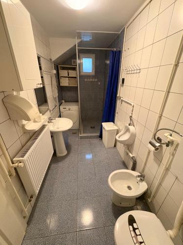 a bathroom with two toilets and two sinks and a shower at Elegant in Zrenjanin