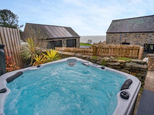 a hot tub in the backyard of a house at Stable Cottage - Uk10694 in Amroth