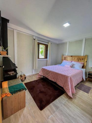 ein Schlafzimmer mit großem Bett und Fenster in der Unterkunft Chalé Quinta São Miguel 01 - Econômico in Santo Antônio do Pinhal