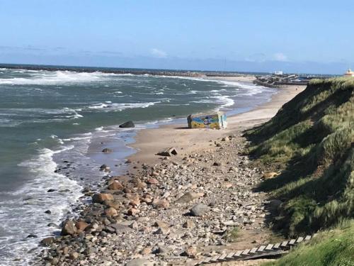 a van parked on a beach next to the ocean at 6 person holiday home in Hirtshals in Hirtshals