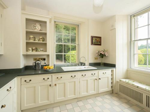 a white kitchen with a sink and a window at Bell Flat - Uk42250 in Broughton