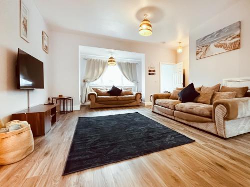 ニュービギン・バイ・ザ・シーにあるRothsay Beach Houseのリビングルーム(ソファ2台、テレビ付)