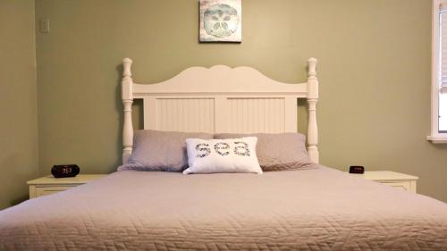 una camera da letto con un letto bianco con due cuscini di Bay Escape a North Cape May
