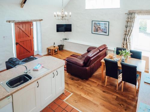 a kitchen and living room with a couch and a table at Flemish Cottage - Uk6720 in Lydstep