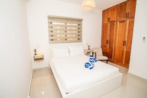a white bed in a room with a window at Tropical Getaway with pool & steps to the beach in Puerto Plata