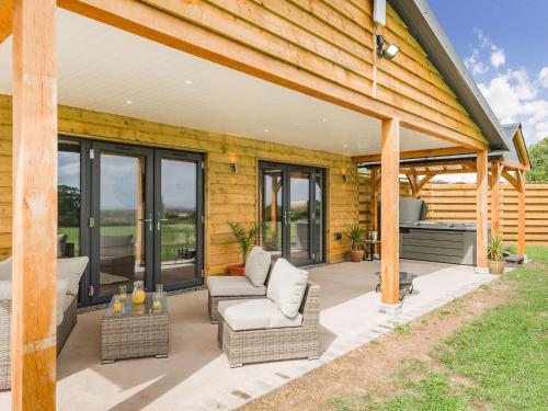 an outdoor patio with chairs and a grill at Oak Tree Lodge - Uk38383 in Lyonshall