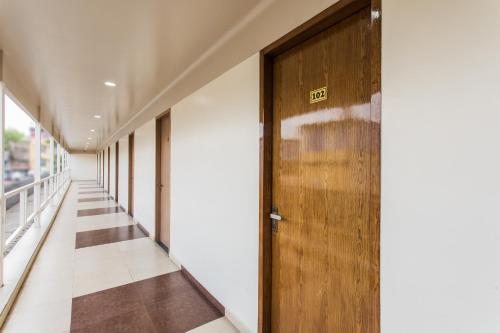 a hallway with a wooden door in a building at Hotel O Riddhi Siddhi in Indore