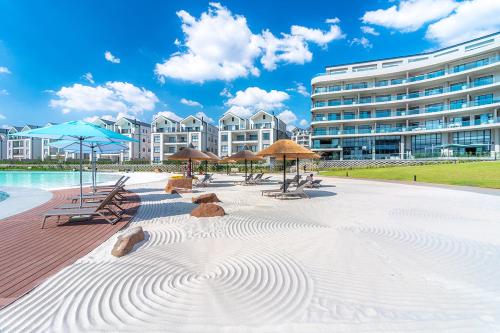 ein Strand mit Stühlen und Sonnenschirmen sowie ein Gebäude in der Unterkunft Waterfall Munyaka Estate in Midrand