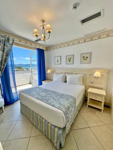 a bedroom with a bed with a view of the beach at Destino Floripa Jurerê In - IL Campanario in Florianópolis