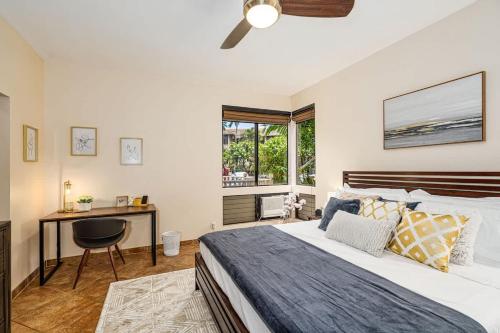 a bedroom with a bed and a desk and a window at Wailea Luxury Retreat Walk to Beach & Shops in Wailea