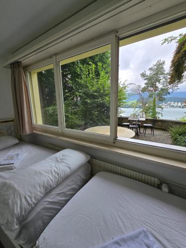 a bedroom with two beds and a large window at Queen Home1 in Lucerne