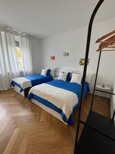 バーゼルにあるBaselStadtのベッドルーム1室(青と白のシーツが備わるベッド2台付)