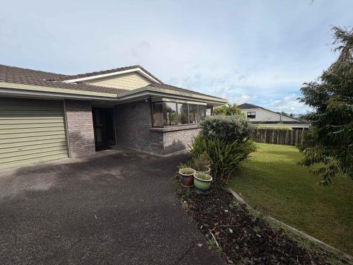 une maison avec un garage et quelques plantes dans un jardin dans l'établissement Kiwi Classic, à Red Beach