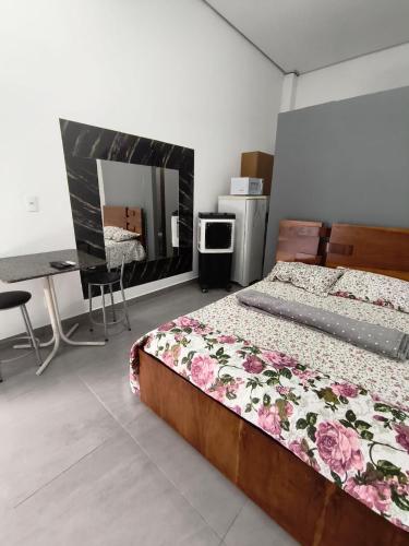 a bedroom with a bed and a desk and a mirror at Lar Doce Lar Realizando Sono suíte1 in Arcos