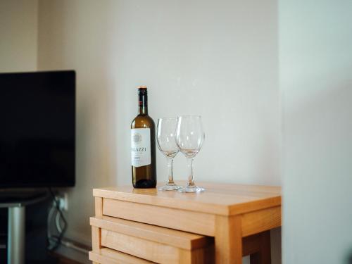 a bottle of wine and two wine glasses on a table at Dolphin Cottage - Uk6733 in Lydstep