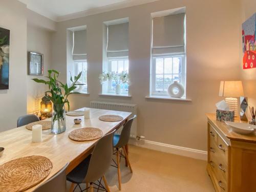 a dining room with a table and chairs and windows at The Court House - Uk43908 in Silloth