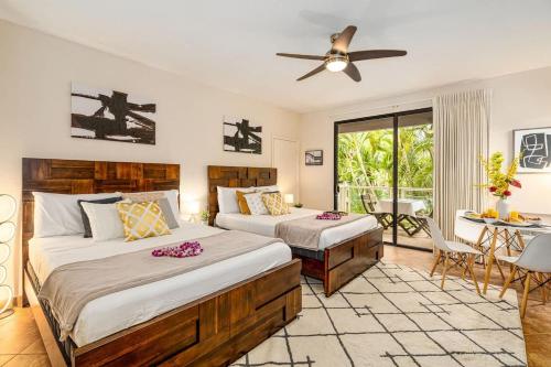 a bedroom with two beds and a ceiling fan at Serene Maui Retreat Walk to Beach & Shops in Wailea
