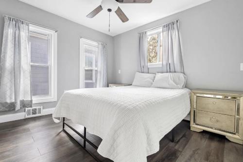a white bedroom with a bed and two windows at Modern 5BR Home Perfect for Families in Niagara Falls