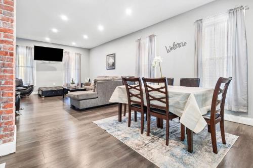 a living room with a table and chairs and a couch at Modern 5BR Home Perfect for Families in Niagara Falls