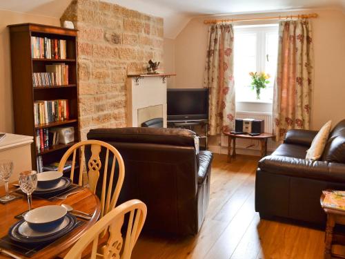 a living room with a leather couch and a table at The Old Vicarage in Curbar