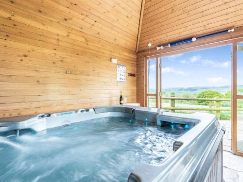 een hot tub in een kamer met een houten muur bij Edderton Hall Country House in Forden