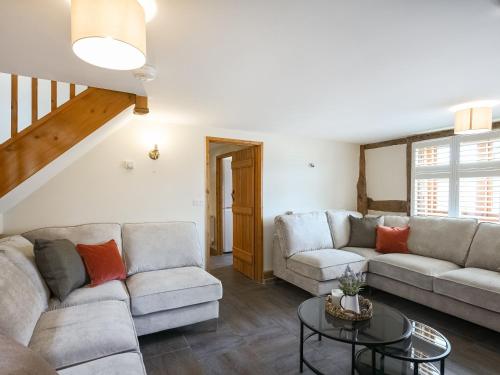 a living room with two couches and a table at Uk46589 - Kibble in Church Stretton
