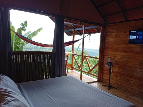 a bedroom with a bed and a large window at Hotel Cabañas Del Quindio in Filandia