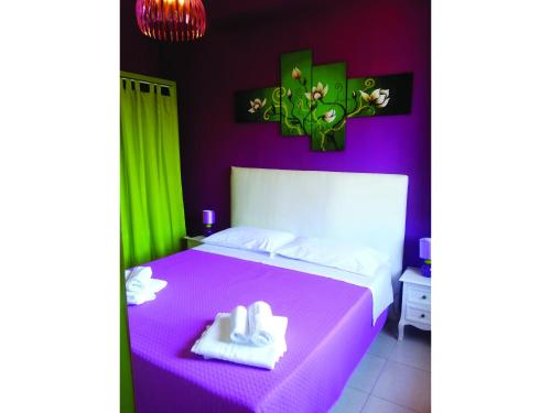 コゼンツァにあるB&B Night & Dayのベッドルーム1室(紫色のベッド1台、タオル2枚付)