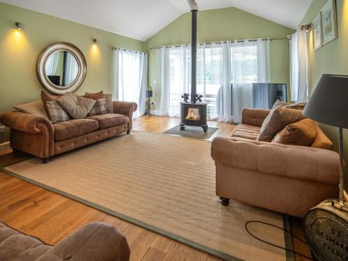 a living room with two couches and a fireplace at Chapelburn in Lawers