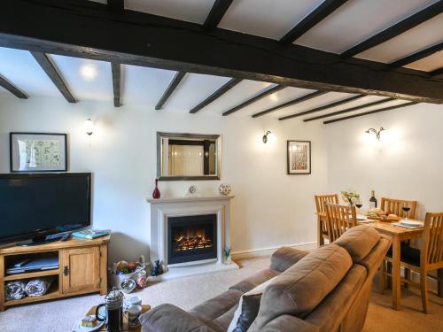 a living room with a couch and a fireplace at Lavender Cottage in Shrewsbury