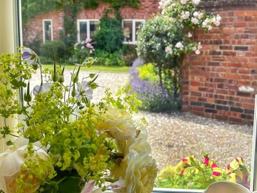 a vase filled with flowers sitting in a window at Lavender Cottage in Shrewsbury