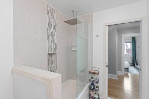 eine Glasdusche in einem weißen Raum mit Flur in der Unterkunft Modern 5BR Corporate Stay 10 Mins to NYC + Parking in Guttenberg