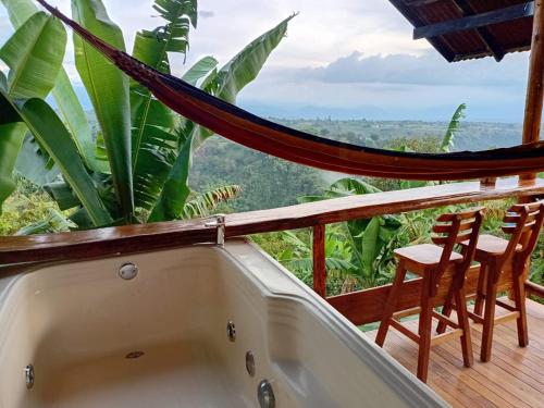 a bath tub on a balcony with a hammock at Cabañas la Miranda in Filandia