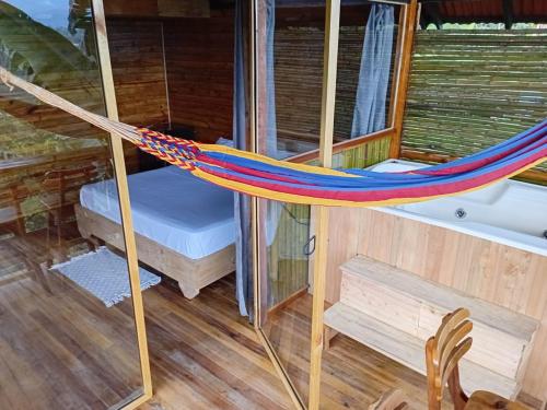 a hammock in a tiny house with a bed at Cabañas la Miranda in Filandia