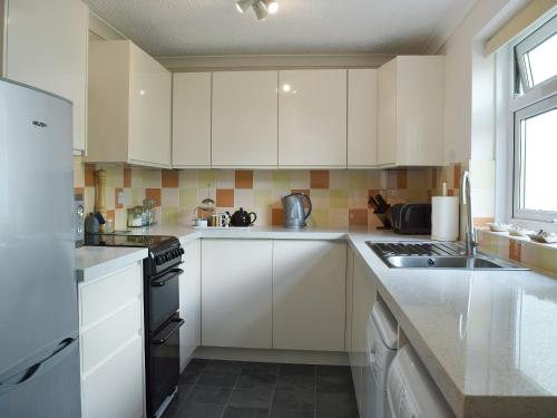 a kitchen with white cabinets and a stove top oven at Ty Clyd - Hw7657 in Walton East